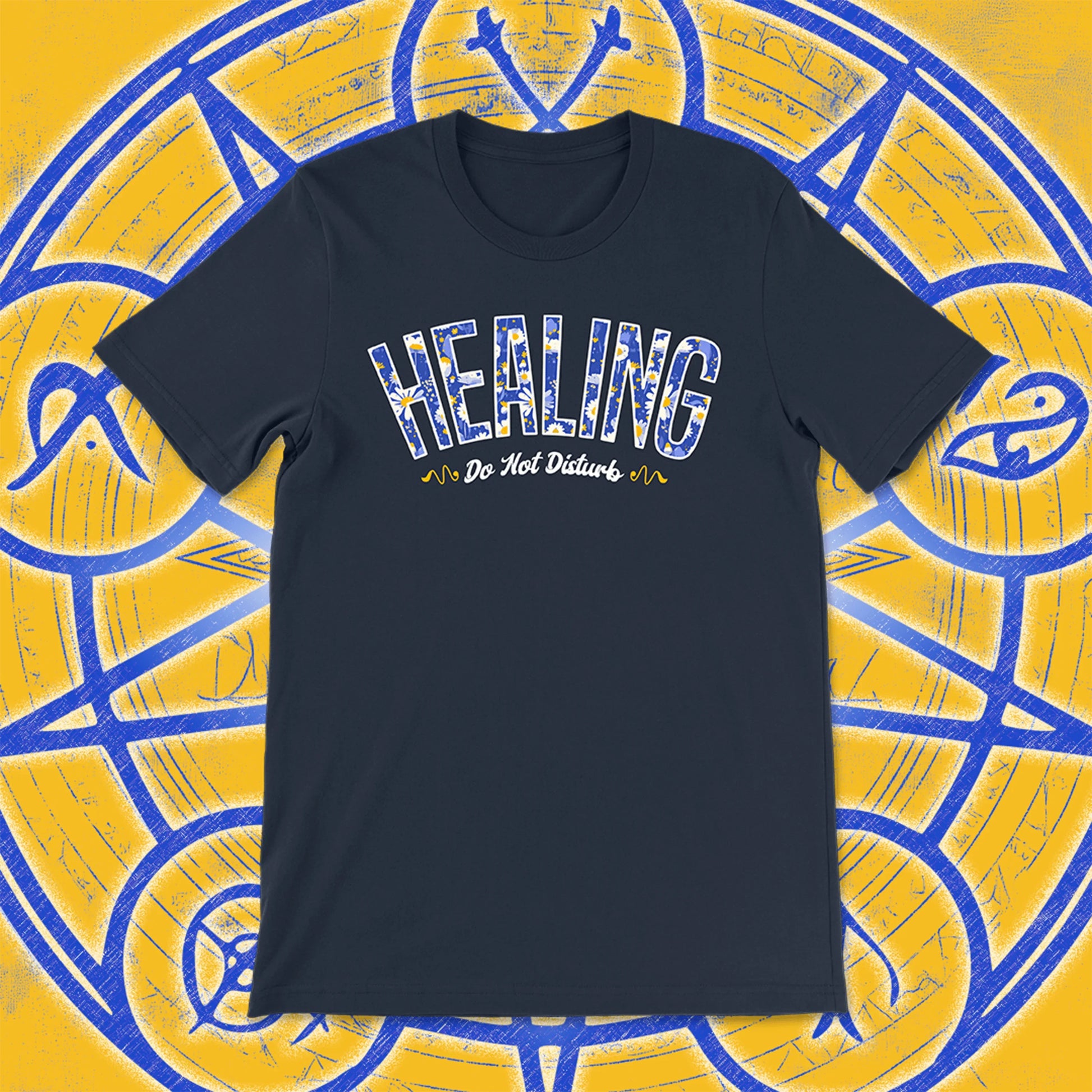 Navy unisex t-shirt with the word “HEALING” in blue and white floral print, and “Do Not Disturb” in cursive beneath. Set against a magical yellow and blue background with arcane symbols.