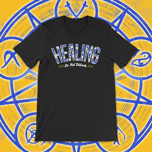 Black unisex t-shirt with the word “HEALING” in blue and white floral print, and “Do Not Disturb” in cursive beneath. Set against a magical yellow and blue background with arcane symbols.