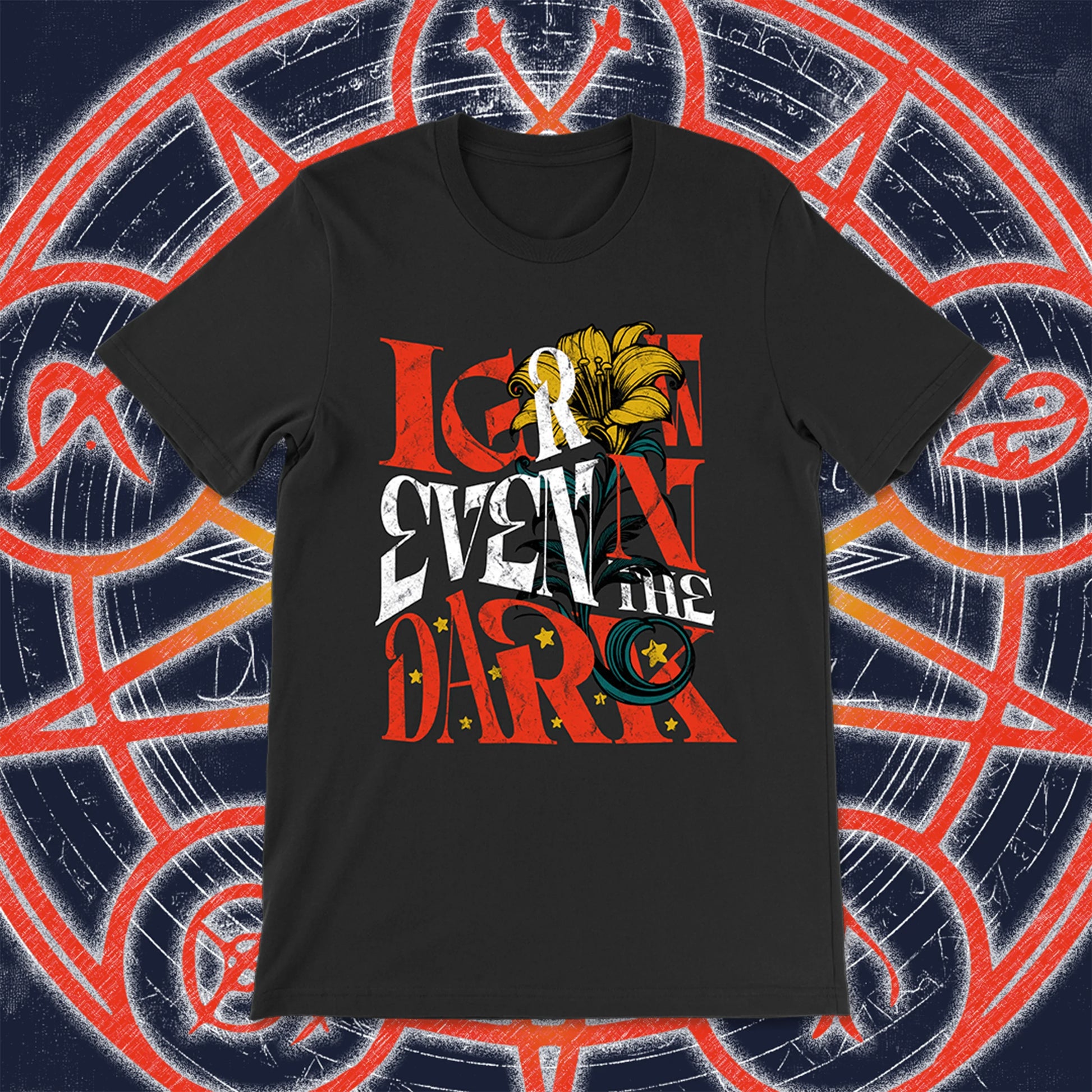 Black unisex t-shirt with the phrase “I Grow Even in the Dark” in stylized red, white, and yellow lettering, adorned with a blooming lily and golden stars. Styled against an arcane, rune-covered background in navy and red.